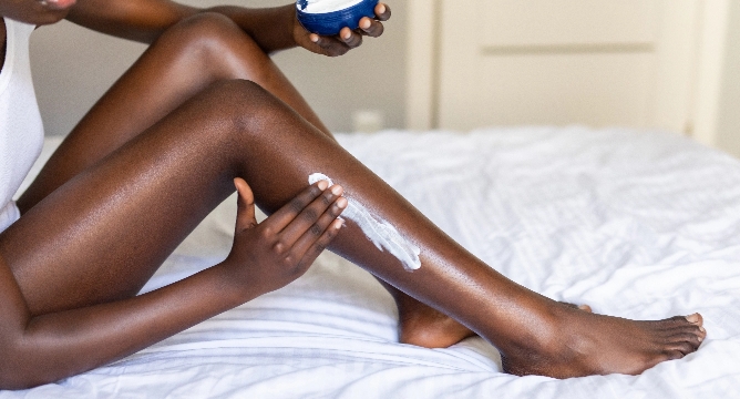 Picture of model applying lotion to leg
