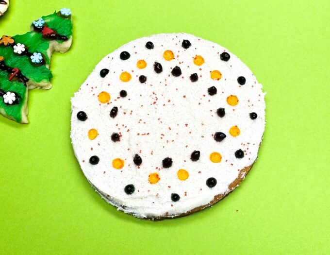 image of decorated round cookie with black/orange dots and green backgound