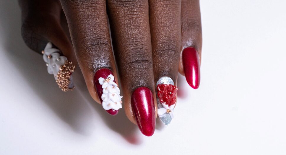 a red nail with white charms chrismax theme nail set